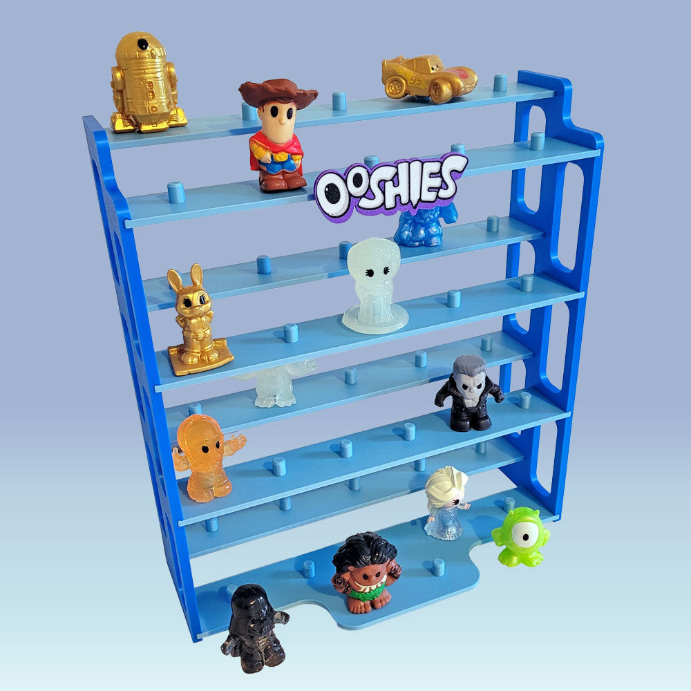A blue and teal plastic Ooshies collectible figure display shelf with multiple tiers, shown holding various small Ooshie figures and accessories against a light blue gradient background.